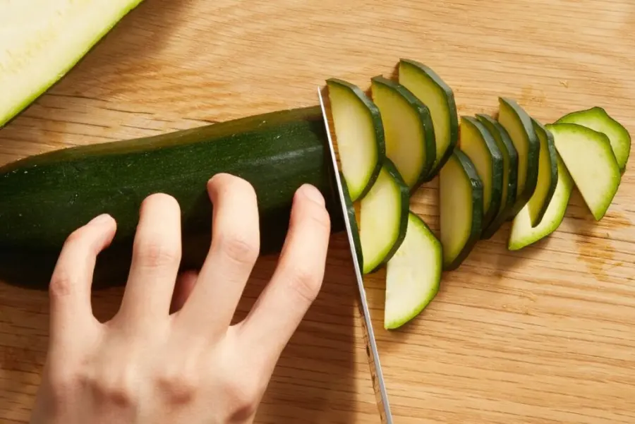 Slicing fresh zucchini on a cutting board